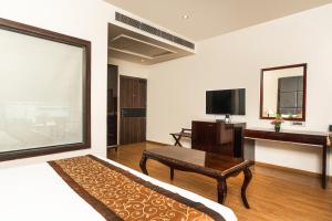 a living room with a bed and a table and a tv at Central boutique hotel in Morādābād
