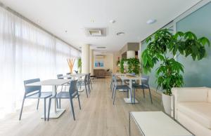 a dining room with tables and chairs and a couch at Hotel Rosanna 3 Stelle Superior in Lido di Jesolo
