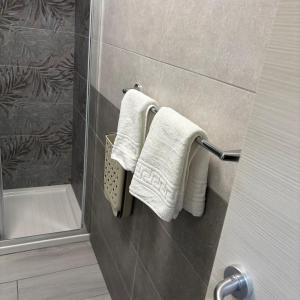 a bathroom with white towels hanging on a wall at Nido di Pace in Giardini Naxos