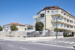 a white fence in front of a building at Grand Hotel in Forte dei Marmi