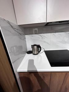 a tea kettle sitting on a counter in a kitchen at River city-Сайран in Almaty +7 photos