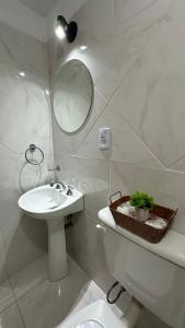 a bathroom with a sink and a toilet and a mirror at Norte Urban Suites in Resistencia +18 photos