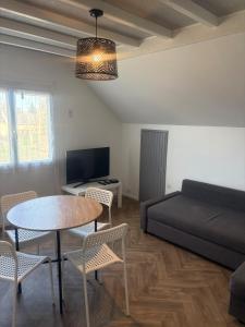 a living room with a bed and a table and chairs at Cozy apartment in Germainville