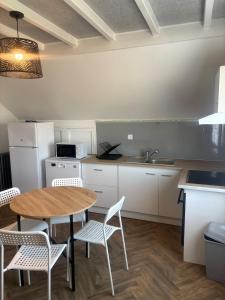 a kitchen with a table and chairs and a sink at Cozy apartment in Germainville