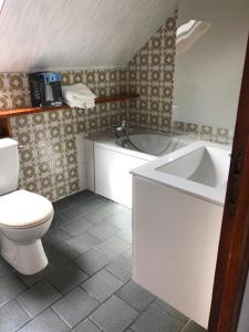 a bathroom with a toilet and a tub and a sink at Cozy apartment in Germainville
