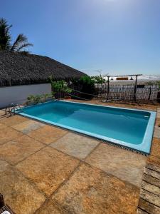a blue swimming pool with the beach in the background at Casa Monã in Maceio