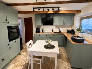 a kitchen with green cabinets and a table with flowers on it at Anis Obsthof in Bad Arolsen