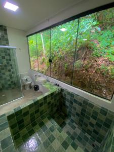 a bathroom with a glass shower and a toilet at Raizes do Mar Hotel - Pé Na Areia - Opções de Suites com Ofuro Aquecido, SPA Privativo, Vista ao Mar ou Montanha, com Estacionamento e Café Incluso in Guarujá