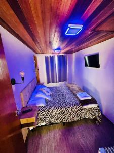 a bedroom with a large bed with a wooden ceiling at Vista das Montanhas in Monte Verde