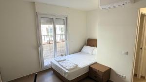 a small bedroom with a bed and a window at Apartamentos Lin in Lloret de Mar