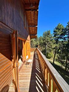 a wooden deck of a cabin with a chair on it at Chalet individuel 11 personnes in Font-Romeu