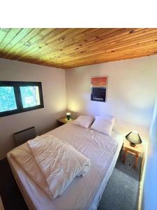 a bedroom with a white bed with a wooden ceiling at Chalet individuel 11 personnes in Font-Romeu +4 photos