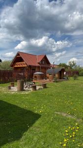 a wooden pavilion with a picnic table in a field at Domki u Wiesi in Giżycko