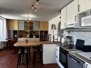 a kitchen with white cabinets and a wooden table at Holiday Home La houle by Interhome in Cancale