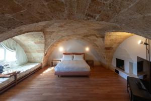 a bedroom with a bed in a stone walled room at Monteforte Suite & Spa in Ugento