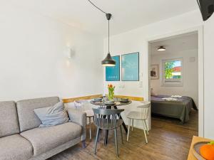 a living room with a couch and a table and chairs at Apartment Seewind by Interhome in Lembruch