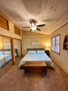 a bedroom with a bed and a ceiling fan at Cozy Beaver Lake Getaway in Lowell