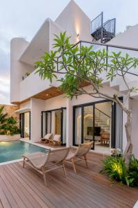 a villa with a swimming pool and a house at Enso Villa and Hotel in Munggu