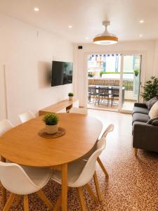 a living room with a wooden table and chairs at Gran piso cerca del mar in Puerto de Gandía