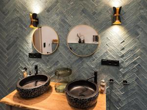 a bathroom with two sinks and mirrors on a wall at Anis Obsthof in Bad Arolsen +33 photos