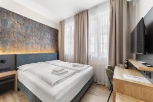 a bedroom with a bed and a desk and a television at NEU - Sona Design Rooms - CITY CENTER - in Bamberg