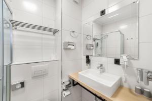 a white bathroom with a sink and a mirror at NEU - Sona Design Rooms - CITY CENTER - in Bamberg