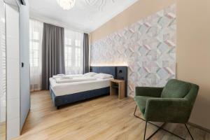 a bedroom with a bed and a green chair at NEU - Sona Design Rooms - CITY CENTER - in Bamberg
