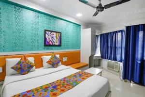 a bedroom with two beds and a green wall at FabHotel Backstreet, Bhopal Railway Station in Bhopal +38 photos