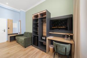 a living room with a tv and a couch and a chair at NEU - Sona Design Rooms - CITY CENTER - in Bamberg