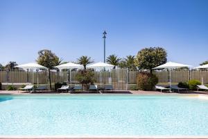 a swimming pool with chairs and umbrellas at Grand Hotel in Forte dei Marmi