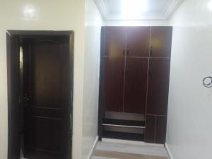 a room with a closet with brown cabinets and a door at Edo Global Boutique apartment in Benin City