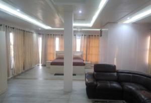 a living room with a couch and a bed at Edo Global Boutique apartment in Benin City +2 photos