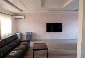 a living room with a couch and a flat screen tv at Edo Global Boutique apartment in Benin City