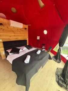 a bedroom with a large bed in a red tent at Glamping Izerska Bajka in Mirsk