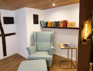 a room with a chair and a table with books at Anis Obsthof in Bad Arolsen