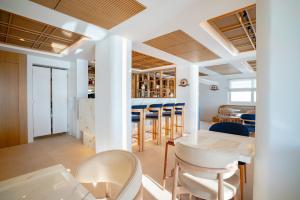 a dining room with white columns and tables and chairs at Apeiron Blue Santorini by Apeiron Hotels in Fira +167 photos