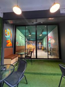 a restaurant with tables and chairs and a large window at Pupa Rooms in Patong Beach