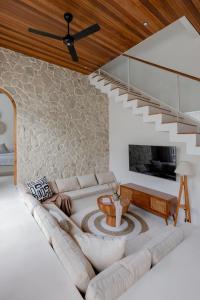 a living room with a couch and a staircase at Enso Villa and Hotel in Munggu +44 photos