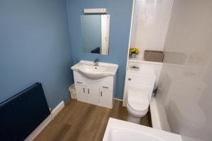 a bathroom with a white toilet and a sink at The City in Durham