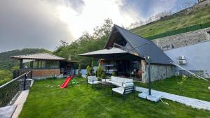 a backyard with a table and chairs and a building at Lefkali HOME in Çınarlık