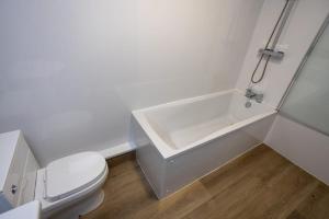 a white bathroom with a toilet and a sink at The City in Durham