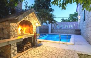 a pool with a stone fireplace next to a swimming pool at Stone house Lila Kamenmost Imotski in Kamenmost