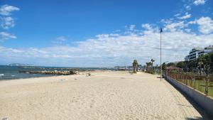 a sandy beach next to the ocean on a cloudy day at UniKlajd Villa-s in Golem