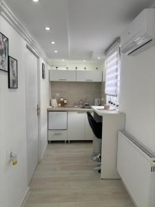 a kitchen with white cabinets and a counter top at Diamond apartment in Kikinda