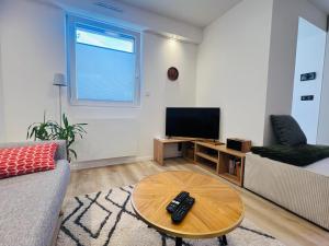 a living room with a couch and a table at Maison climatisée indépendante et de plein pied in Bischoffsheim