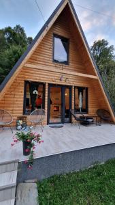 a log cabin with a large patio in front of it at Cabana A Morarului in Teiuş