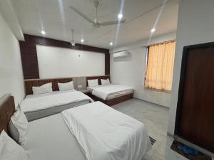 a room with two beds and a tv in it at Hotel Shree Radhe Mohan And Resort in Khātu
