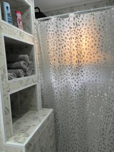 a shower with a shower curtain in a bathroom at Diamond apartment in Kikinda