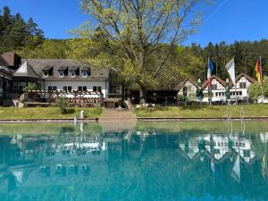 a house sitting next to a large body of water at Die Heilsbach gGmbH in Fischbach