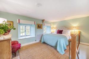 a bedroom with a bed and a window at Puddle Cottage in Dorchester